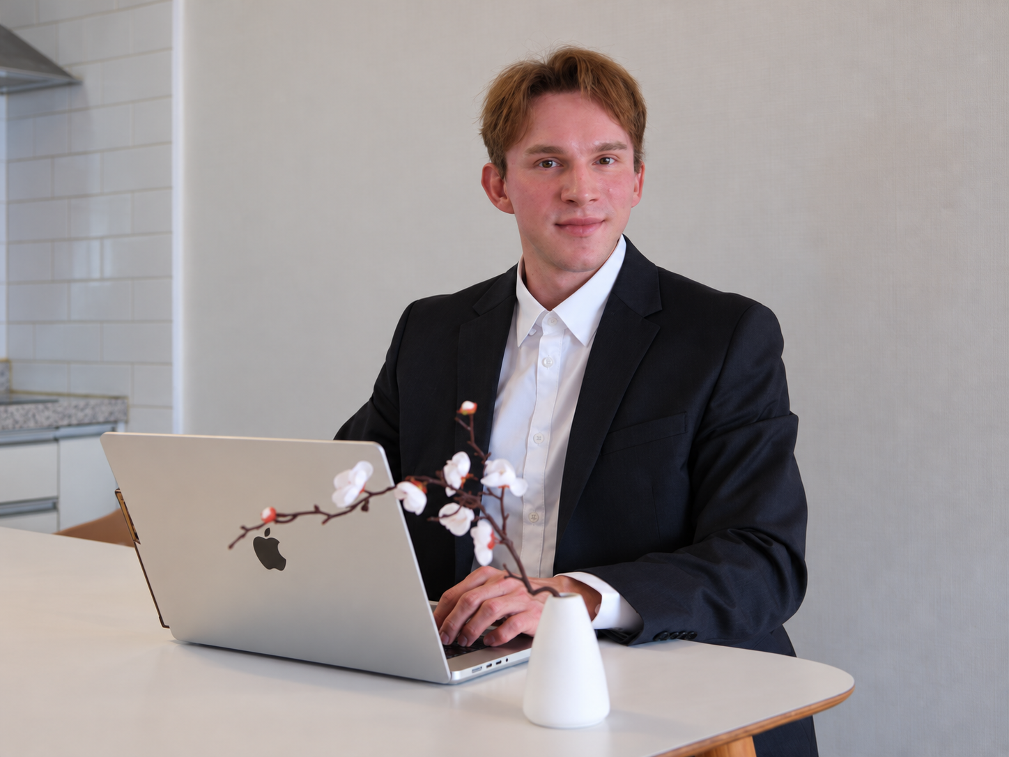 Aaron working at a laptop in a navy suit