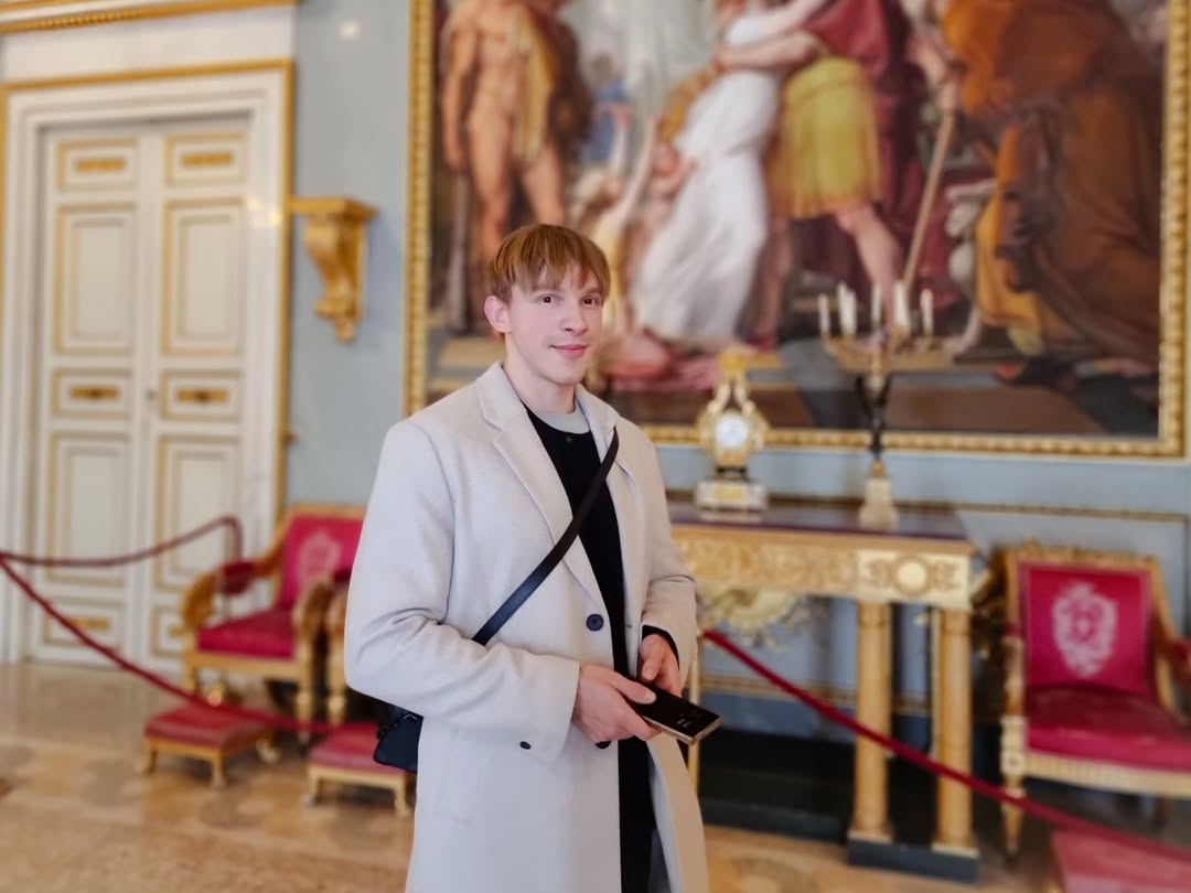 Aaron in a light coat visiting a museum