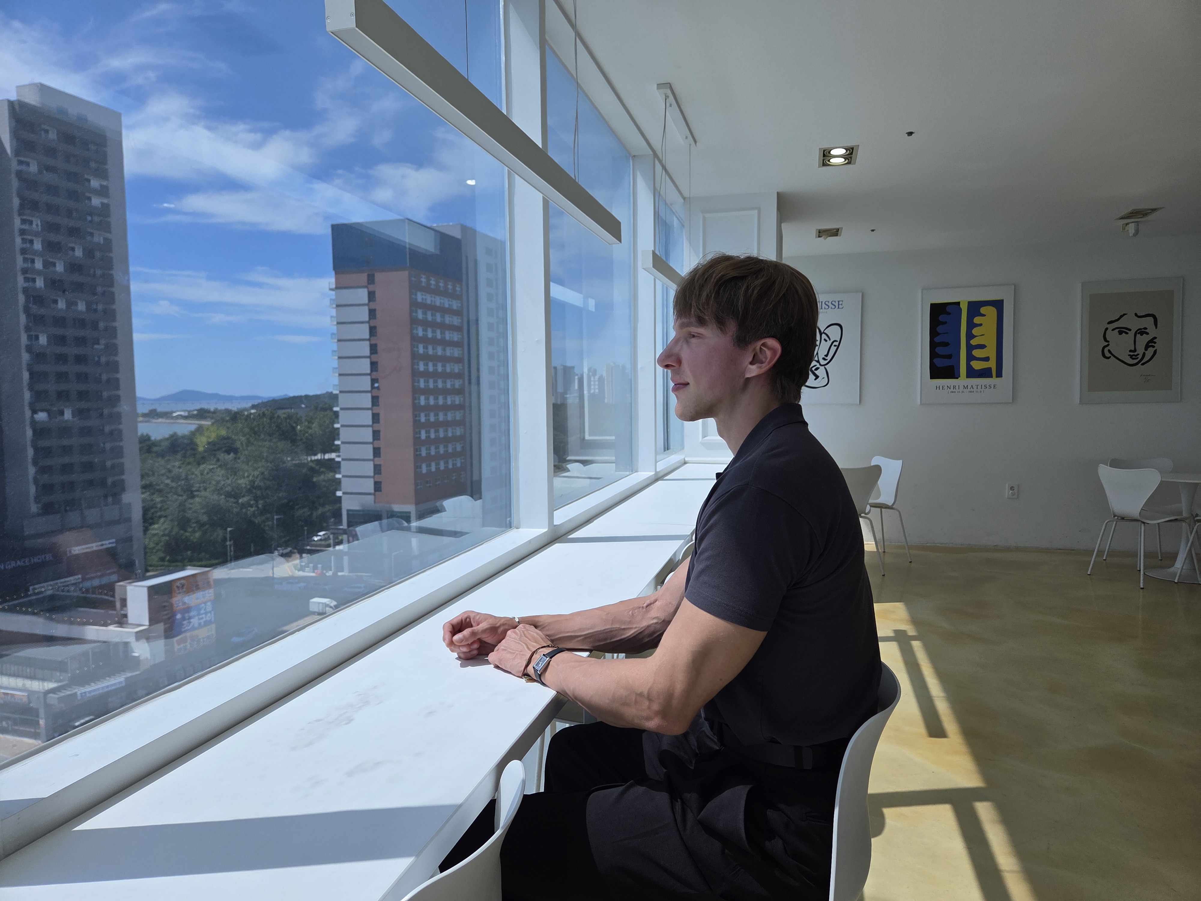 Aaron seated beside a window overlooking the city